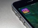 Close-up image of a smartphone screen displaying the Instagram app icon, emphasizing modern technology.