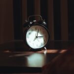 An alarm clock on a wooden table at night