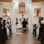 A wedding ceremony takes place in a church with guests
